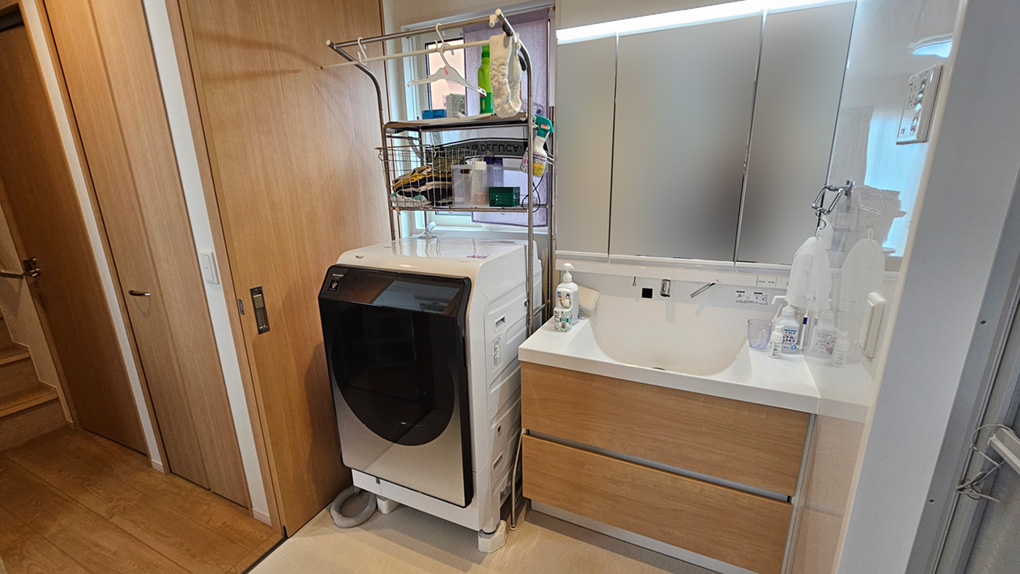 ワイド型の洗面台にドラム式洗濯機も余裕で置ける広々した洗面所の空間。