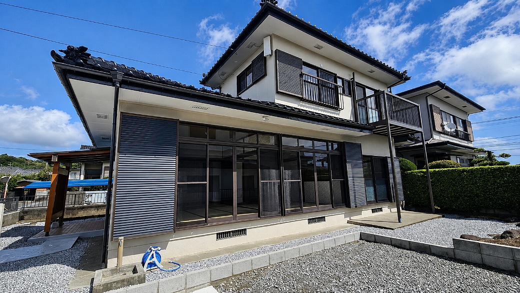 和瓦の外観と庭の余白が印象的。和室から外へ視線が広がる住まいです。