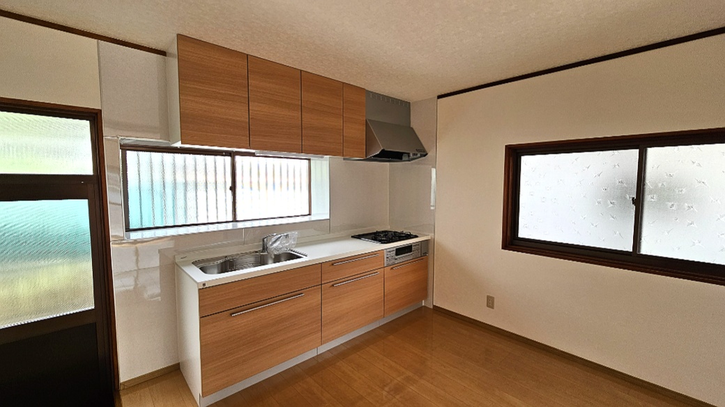 窓のある新調キッチンと勝手口。調理から外への出入りまで動線を取りやすい配置です。
