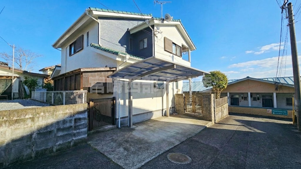 青空に映えるモダンな外観。カーポート付きで雨の日の乗降も快適です。