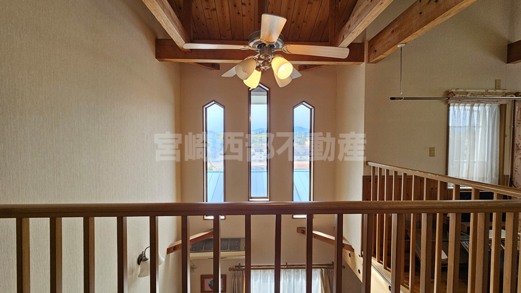 高い位置の窓から光が入る吹抜け。シーリングファンがリゾート感を高めます。