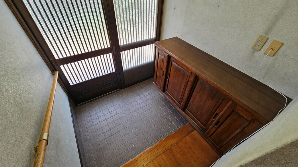 玄関から中2階への階段が見え、一般的な平面間取りとは違う構成が伝わります。