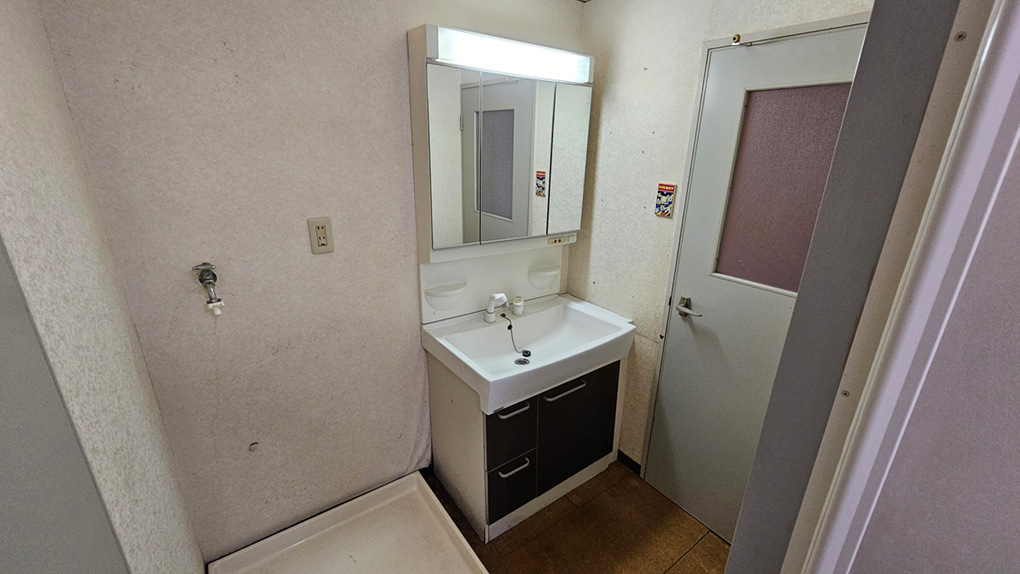 シンプルながら収納付きの洗面化粧台。隣には洗濯機置き場もあります。