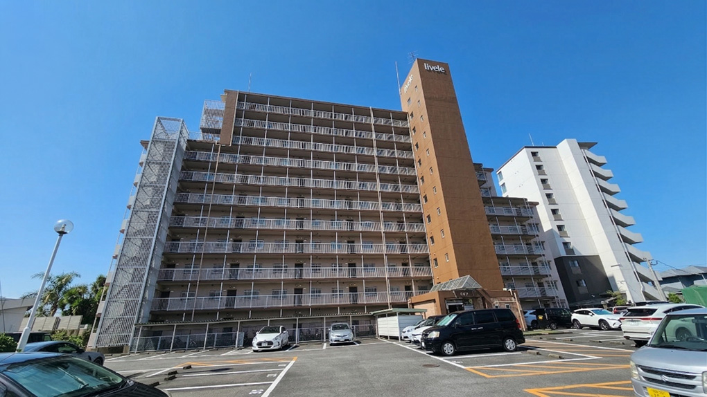 青空に映える重厚な外観。広々とした平置き駐車場で車移動も快適。