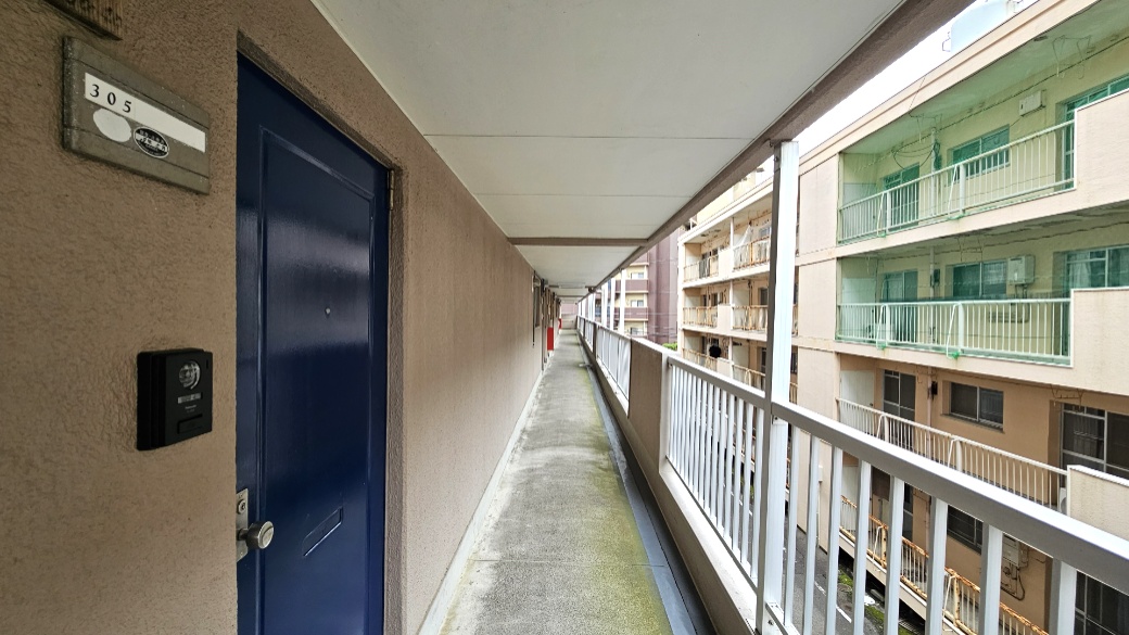 屋根のある外廊下から玄関へ。住戸前の共用部の距離感が分かります。